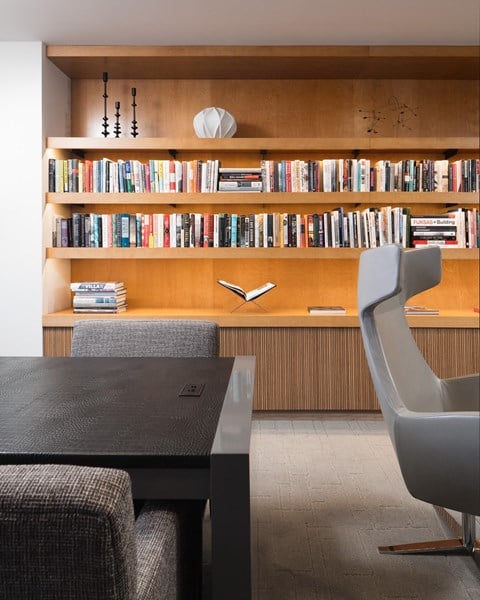 a room with a table and chair in front of a bookshelf